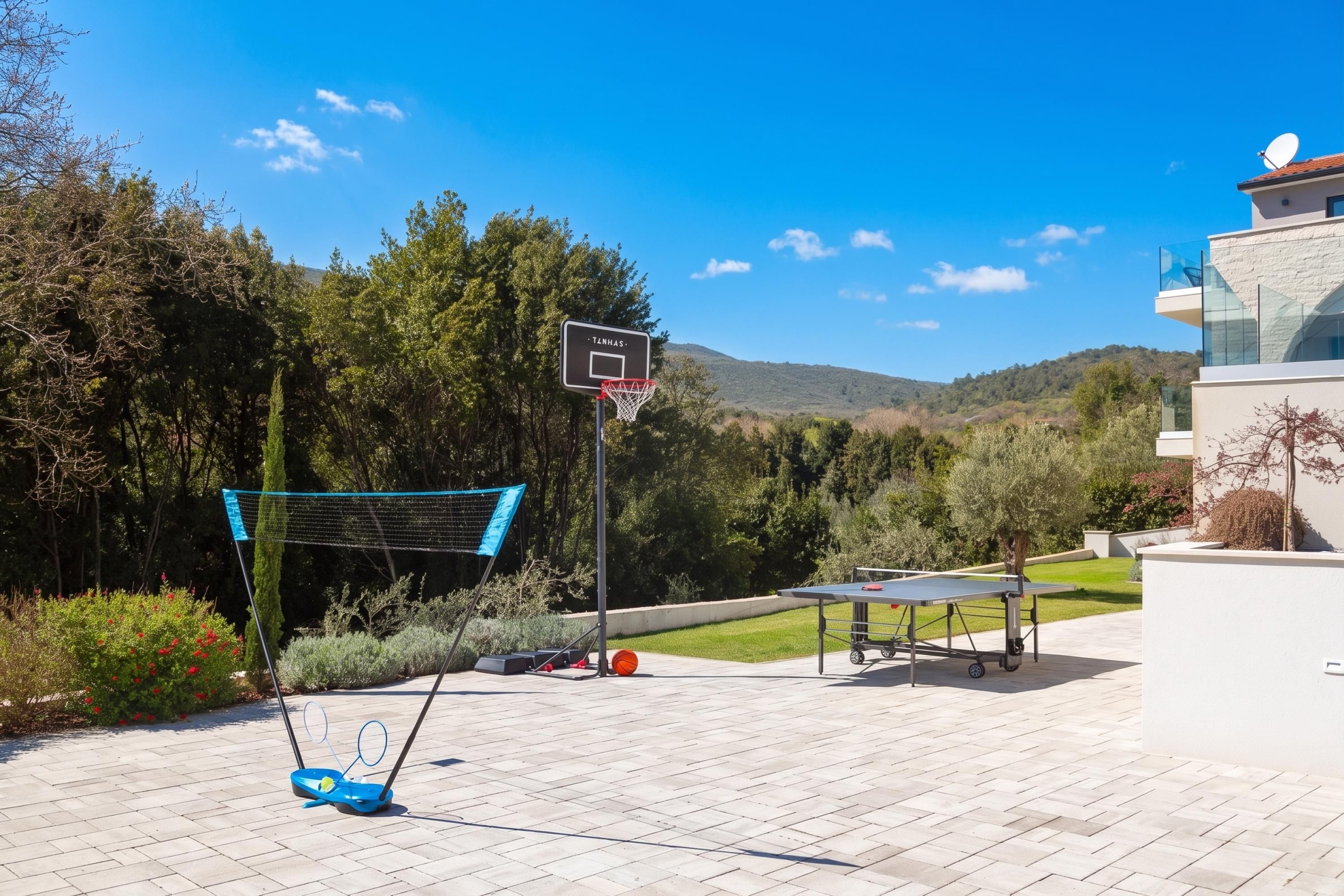 Quadra de basquete externa com cesto, mesa de tênis de mesa e mesa de tênis.