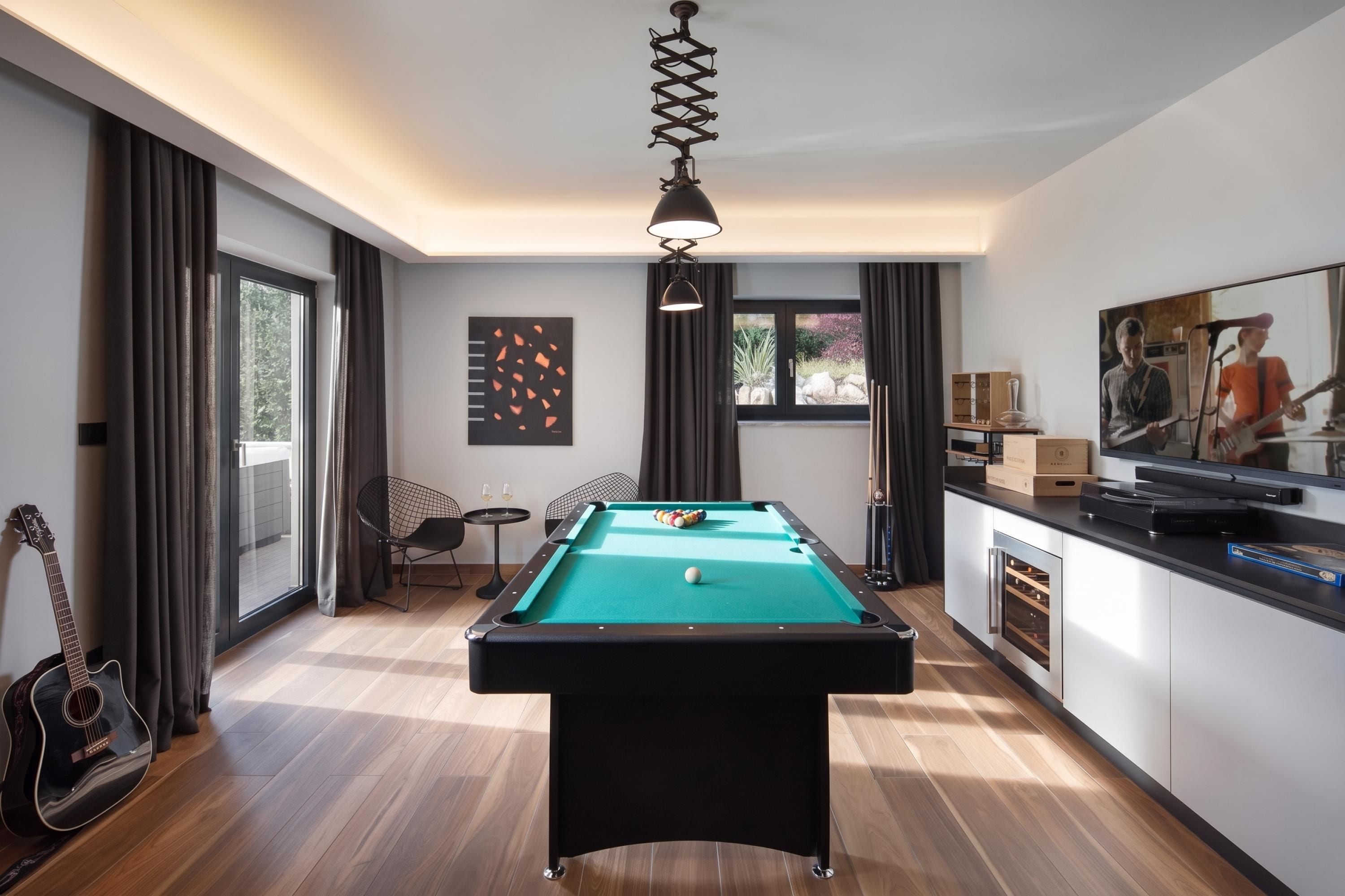 A modern room with a pool table, a guitar, and a dining area with a TV.