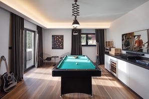 A modern room with a pool table, a guitar, and a dining area with a TV. - Villa Valmata Adriatic Pearl /w Pool & Wellness (Rasa)