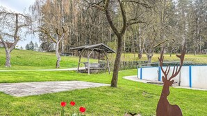 A park with a wooden bench, a deer sculpture, and a metal sphere. - Ferienhof Wolf by Interhome (Viechtach)
