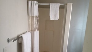 Un baño con ducha, inodoro y barra para toallas.