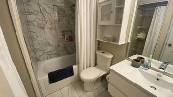 A bathroom with a shower, toilet, and sink.