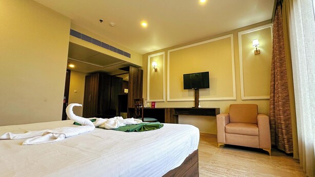 Ein Hotelzimmer mit Bett, Sessel, Fernseher und Kamin.