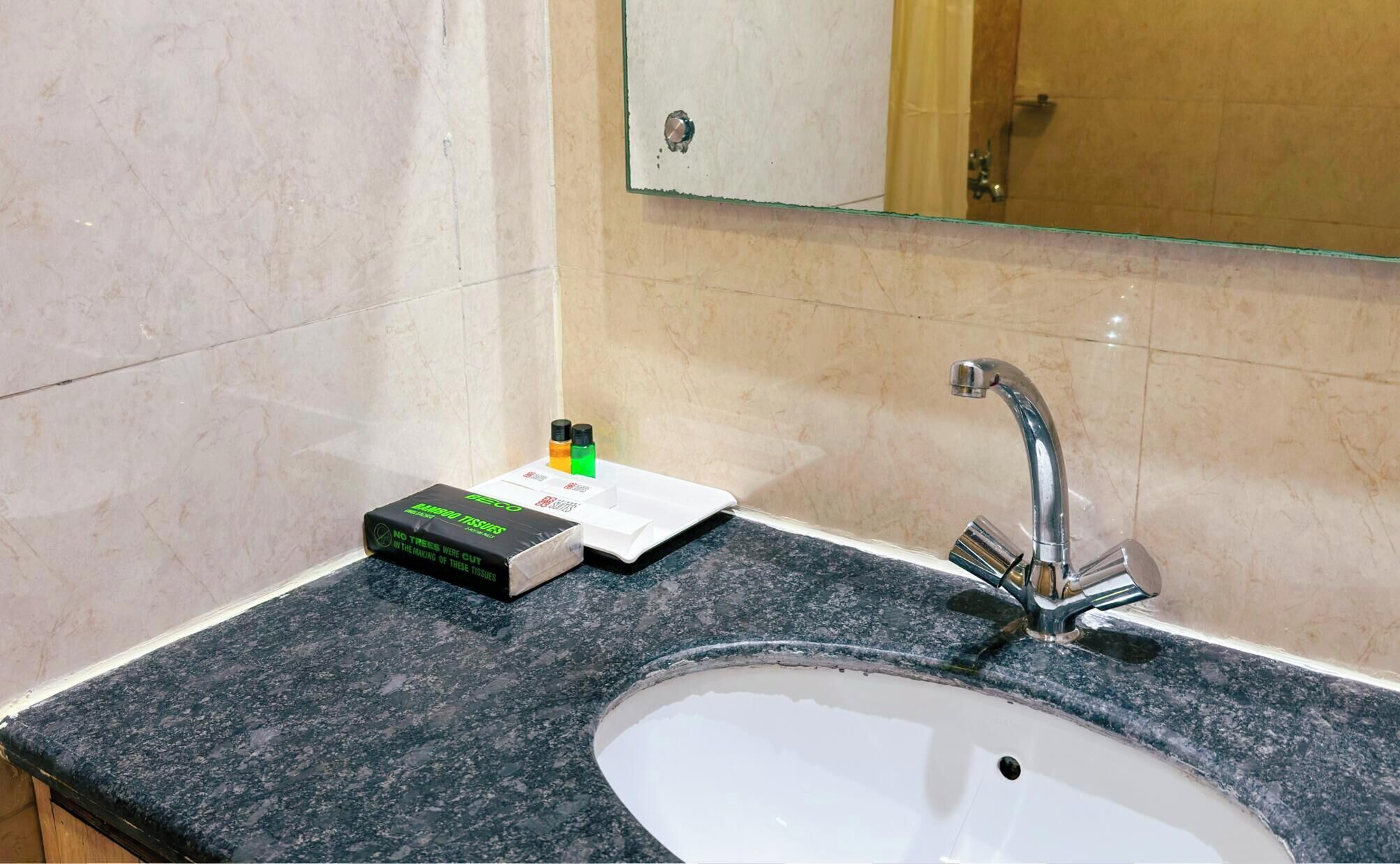 Une salle de bain avec un lavabo en marbre, un miroir et des articles de toilette posés sur le comptoir.