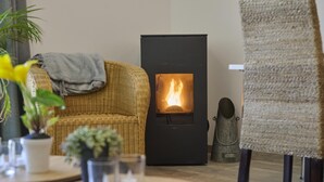 Ein gemütliches Wohnzimmer mit Kamin, Korbmöbeln und einer kleinen Statue.