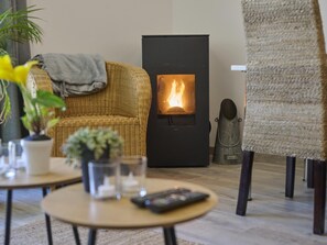 A cozy living room with a fireplace, wicker furniture, and a small statue.