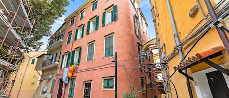 Una calle estrecha flanqueada por edificios, con balcones y una mezcla de estilos arquitectónicos.