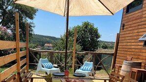A wooden deck with a table and chairs, a pizza on the table, and a view of the surrounding landscape. - Tinyweeny House 15min to Ist Airport (Eyup)
