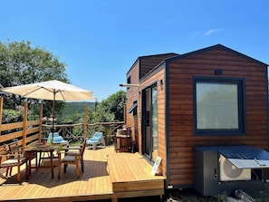 A wooden deck with outdoor furniture, a small building with a large window, and a view of the surrounding landscape. - Tinyweeny House 15min to Ist Airport (Eyup)
