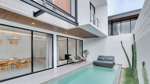 A modern house with a swimming pool, glass doors, and a patio area. - Villa RHYS - Canggu (Canggu)