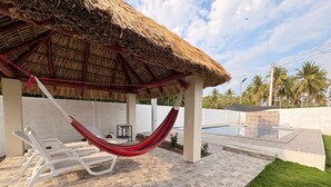 A covered outdoor area with a pool, lounge chairs, and a hammock. - Just 5-minutes away to the beach. Spacious 5-bedroom house at Costa Azul,Metalio (Metalio)