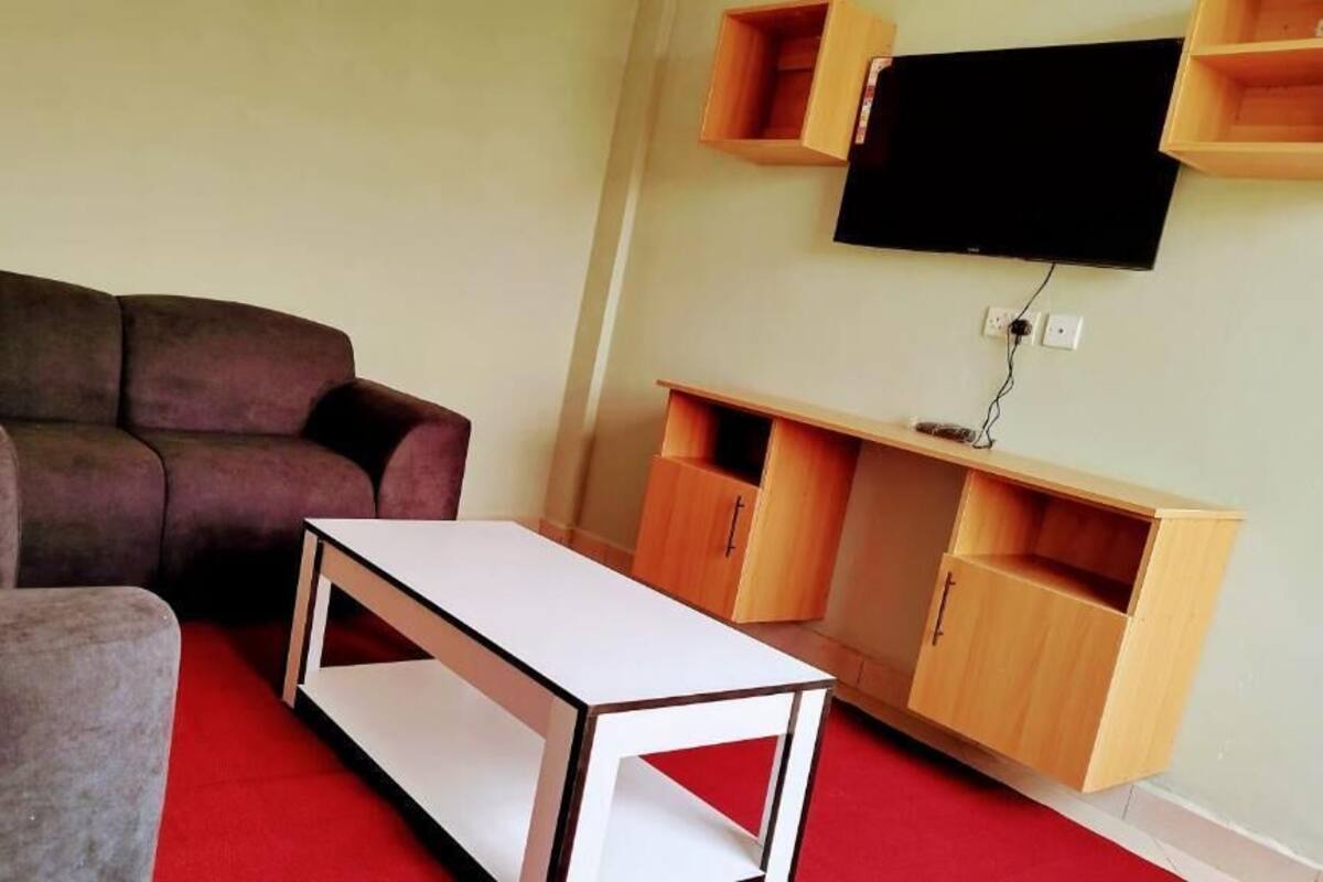 A living room with a sofa, a small white table, and wooden cabinets.