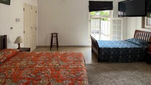 A bedroom with a bed, a ceiling fan, a window, and a TV. - Nora Lyn - Colombo (Colombo)