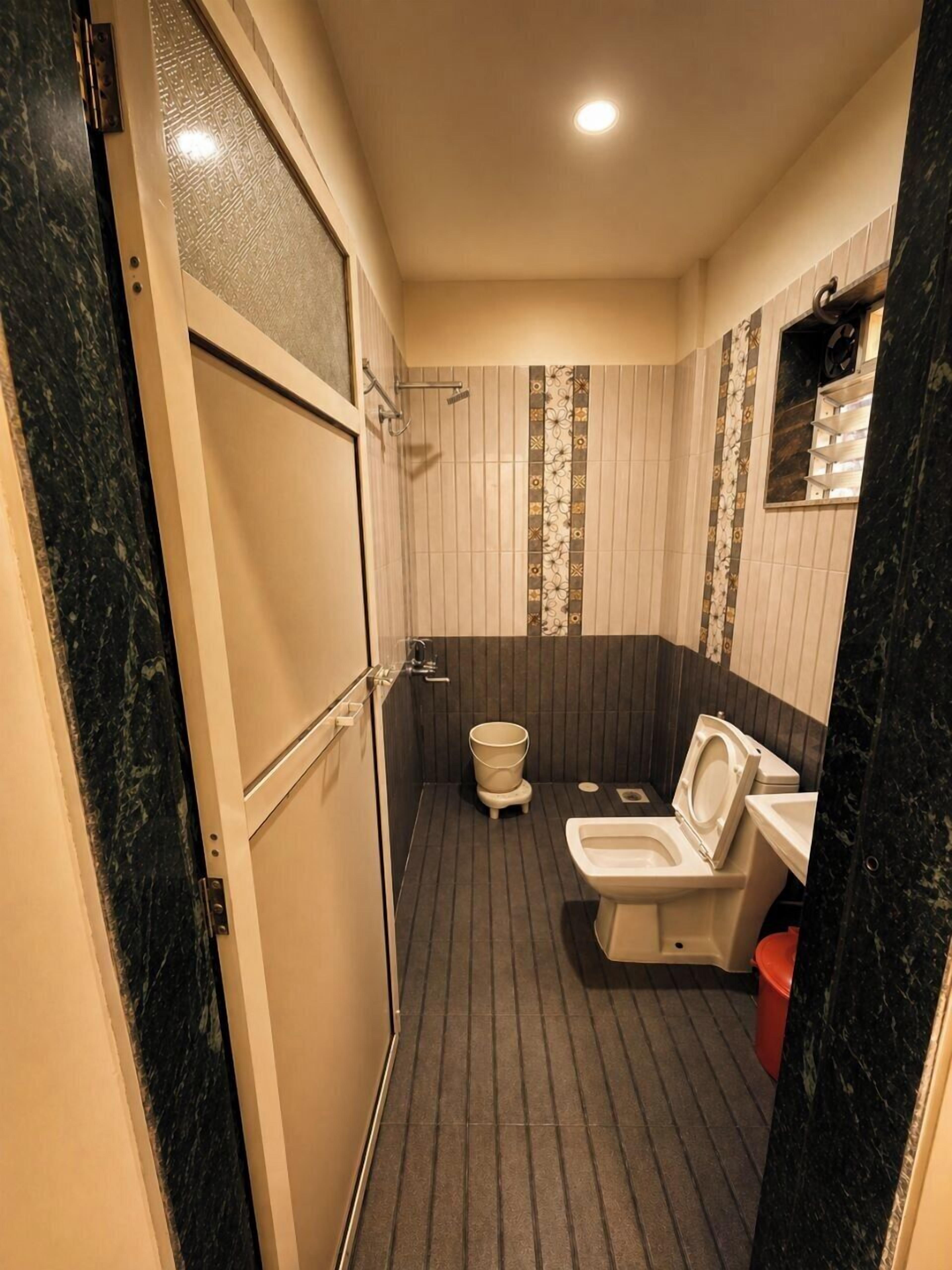 Een kleine badkamer met toilet, bidet en een vuilnisbakje.