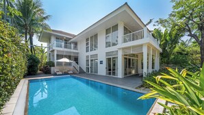 A modern two-story house with a swimming pool, surrounded by lush greenery. - Pool Villas Resort (Da Nang)