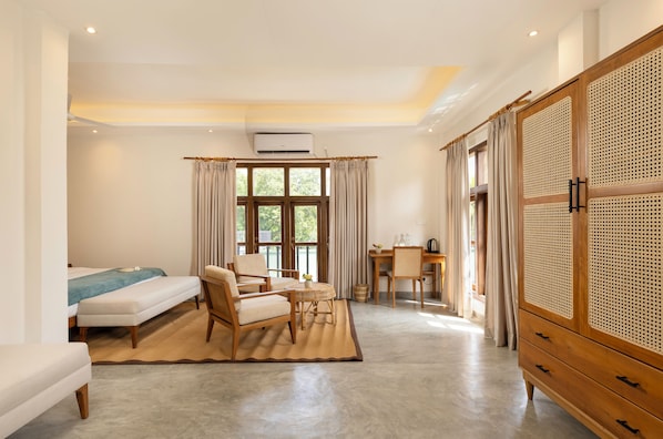 A room with a bed, a desk, a chair, a wardrobe, and a window with curtains.