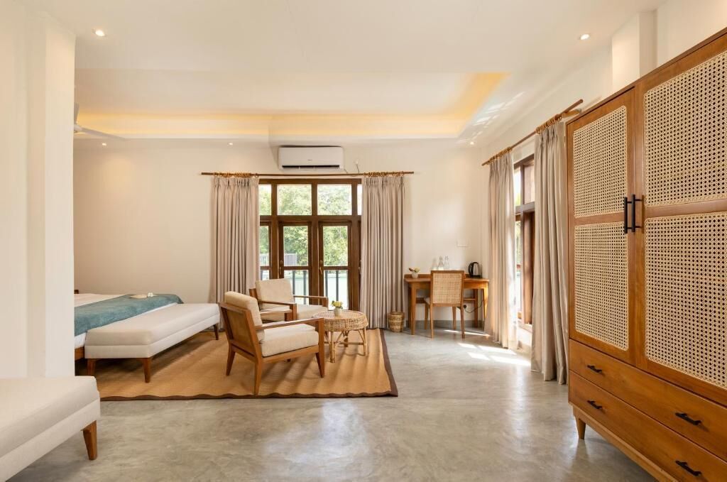 A bedroom with a bed, a chair, a desk, and a wardrobe.