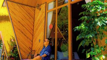 Une cabane en bois avec un lit, une chaise et une plante en pot.
