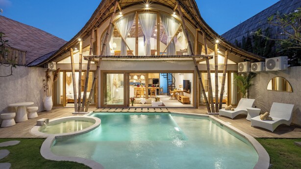 A two-story building with a swimming pool, outdoor seating, and a large window overlooking the pool. - New Villa in Kerobokan - 5 Min to Canggu (Badung)