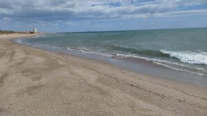 Una platja amb sorra daurada i un cel serè.