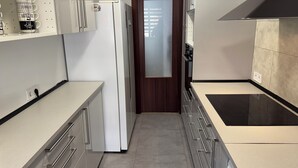 Une cuisine moderne équipée d’un réfrigérateur, de placards, d’un plan de travail et d’une cuisinière.
