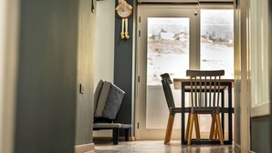 Un pasillo con comedor, un reloj y vistas al exterior.