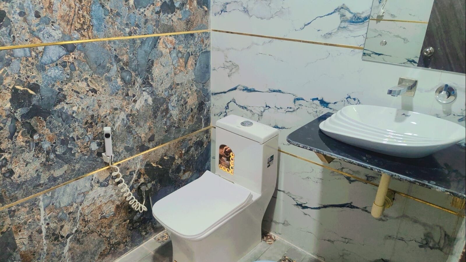 Une salle de bain avec des toilettes, un lavabo et des murs en marbre.