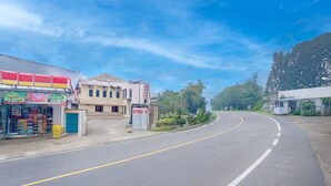 A road curving to the right with a hotel and a convenience store on the left. - Stylish DBL Suite Escape W/ Free Wifi and Parking (Megamendung)