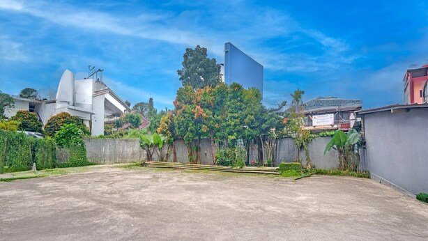 A spacious outdoor area with a concrete surface, surrounded by greenery and buildings. - Stylish DBL Suite Escape W/ Free Wifi and Parking (Megamendung)