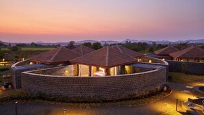 Edificio circular de ladrillo con varias habitaciones y techos de tejas.