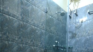 Ein Badezimmer mit Toilette, Dusche und einer gläsernen Duschkabine.