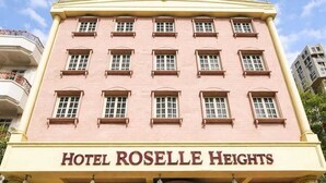 Ein pinkfarbenes Gebäude mit einem Schild, auf dem 'Hotel Roselle Heights' steht.
