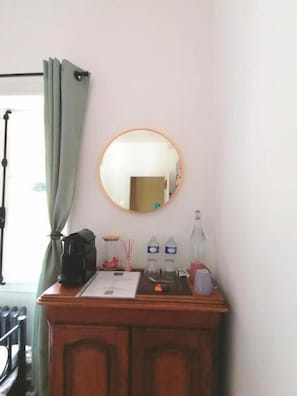 A room with a wooden cabinet, a mirror, a window with curtains, and a door. - Trecastle Chambre d'Hotes (Châlus)