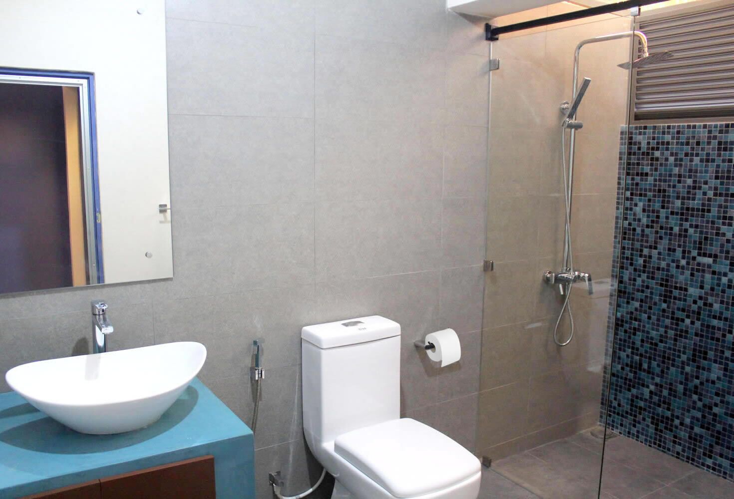 A bathroom with a white sink, toilet, and shower.