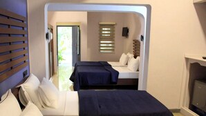 A hotel room with a bed, a sofa, a desk, and a window with blinds. - Morning Star Resort Pvt Ltd (Negombo)