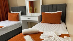 Une chambre d’hôtel avec deux lits, un bureau, un miroir et une salle de bain.