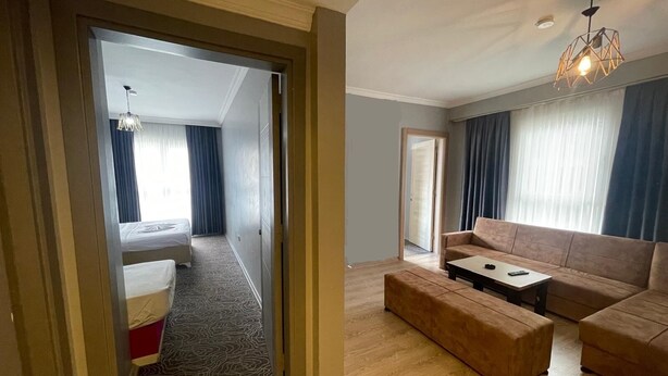 Une chambre d’hôtel avec un lit, un canapé, une table basse et un lustre.