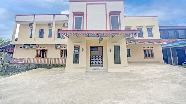 A multi-story building with a flat roof, a central entrance with a decorative gate, and multiple windows. - Luxury Deluxe DBL Retreat W/ Free Wifi and Parking (Megamendung)