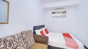 A bedroom with a bed, a sofa, and a wall-mounted air conditioning unit. - Luxury Deluxe DBL Retreat W/ Free Wifi and Parking (Megamendung)