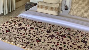 Quarto com cama de dossel, espelho e vista para o exterior.