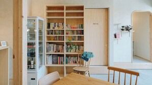 Une bibliothèque avec des étagères, une table et une chaise.