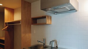 A modern kitchen with a stainless steel sink, a built-in stove, and a wooden staircase. - cuccou (Aira)