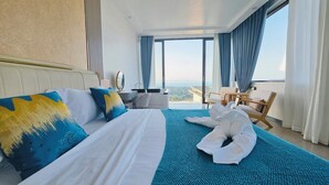 Habitación de hotel con una cama grande, un escritorio, una silla y vistas a la ciudad.