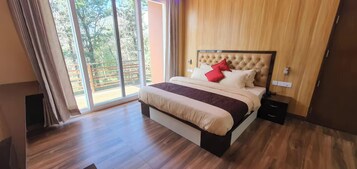 A bedroom with a bed, a nightstand, and a sliding glass door leading to an outdoor area.