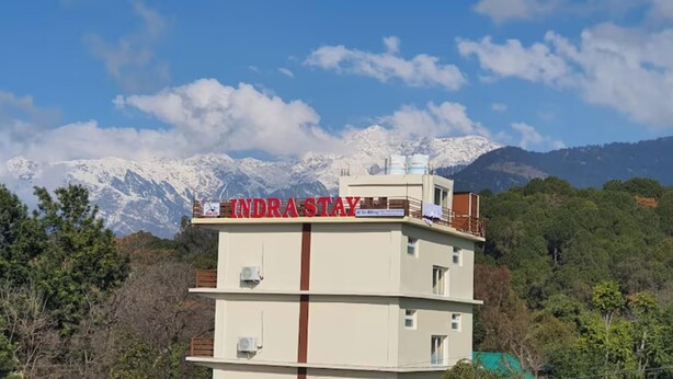 A hotel named 'INDRA STAY' with a view of snow-capped mountains in the background. - Indra Stay by Panache Hotels (Baijnath)