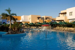A swimming pool with a water fountain, lounge chairs, and palm trees. - Atlantica Mikri Poli Rhodes (Rhodes)