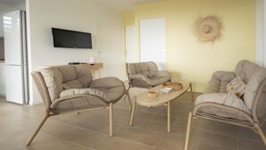 A modern living room with a sofa set, a coffee table, and a flat-screen TV mounted on the wall. - Villa Ty Kas Soley Sainte Luce, sea view and swimming pool (Sainte-Luce)