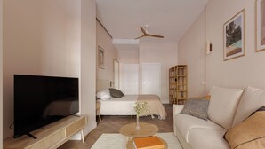 A modern living room with a flat-screen TV, a sofa, a coffee table, and a bookshelf. - MH Apartments Blasco Valencia (Valencia)
