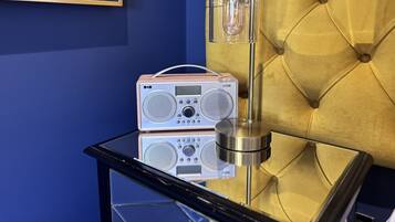 Een radio op een glazen tafel, met een gebobbelde gele hoofdbord op de achtergrond.
