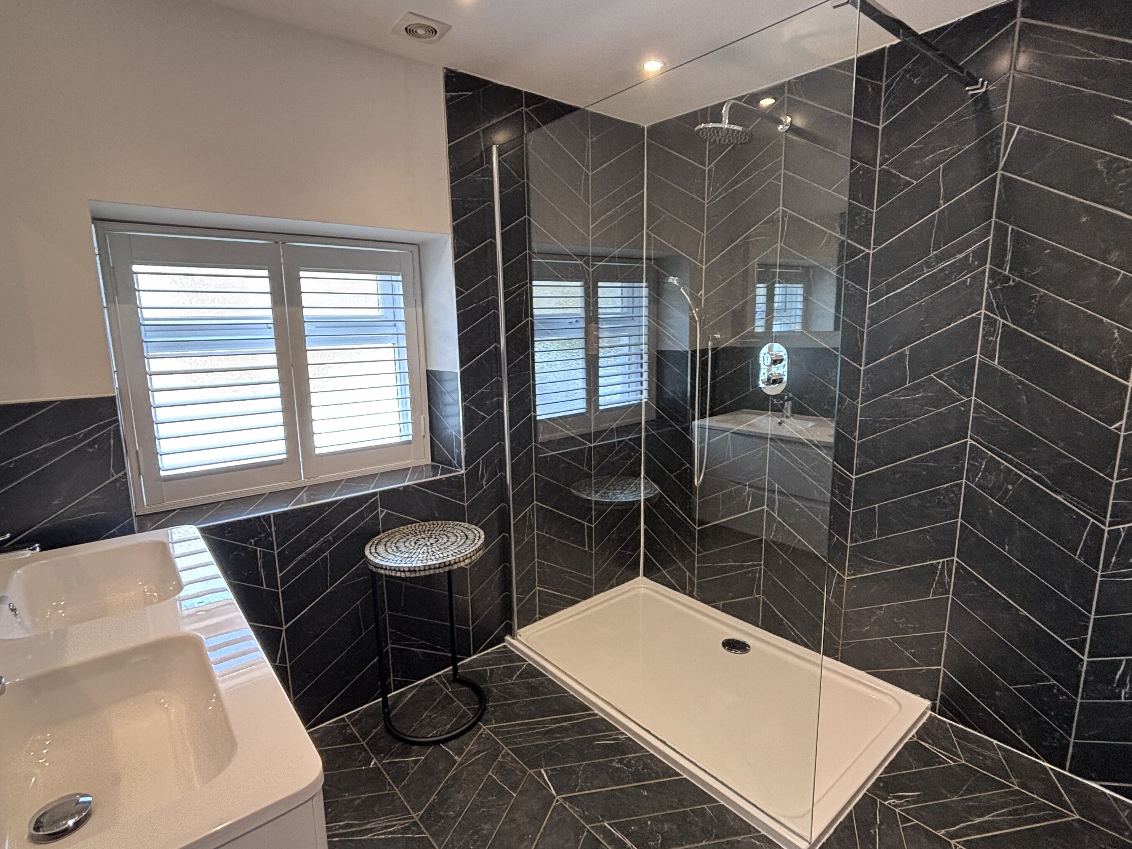Ein modernes Badezimmer mit Badewanne, Dusche und einer Duschkabine aus Glas.